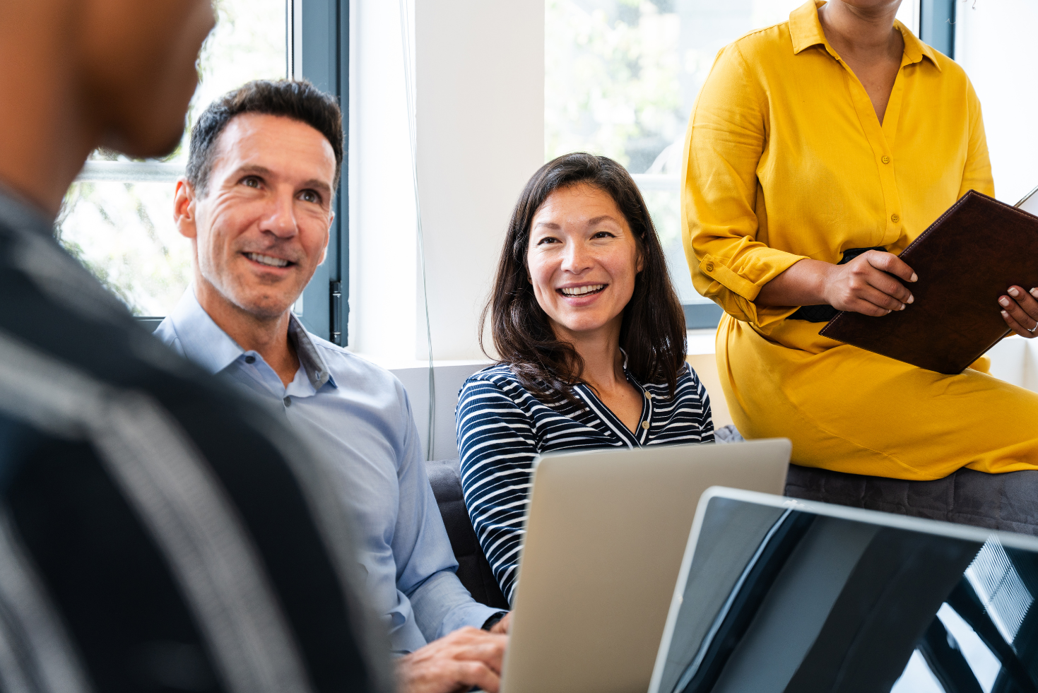 Team of young people working together on laptops in a modern office, representing digital nonprofit work